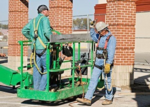 Two workers looking at damage on a building after an earthquake